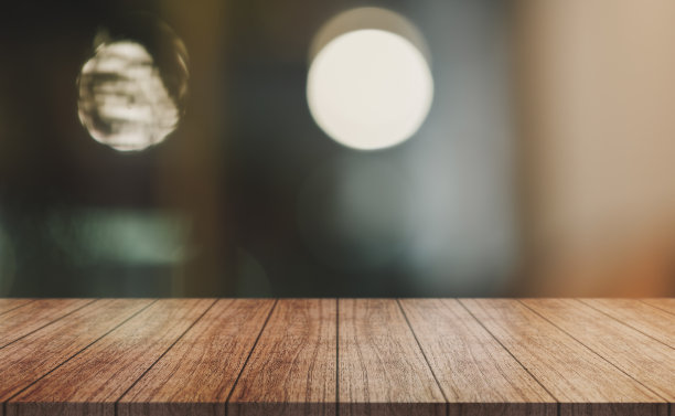空的木制桌面与灯光散焦模糊的餐厅背景。图片下载