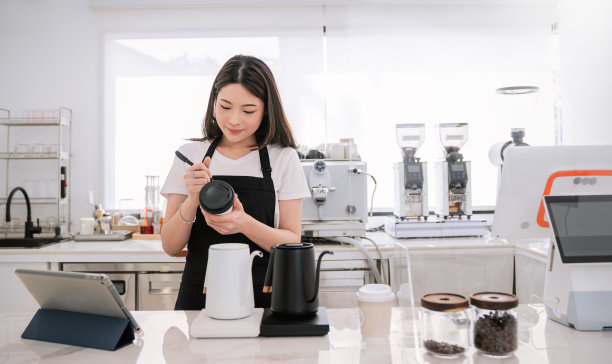 创业成功的小企业主中小企业的女人，美女女孩白色的名字在咖啡店的纸杯餐厅。亚洲女咖啡师肖像咖啡馆老板。中小企业创业商概念图片下载
