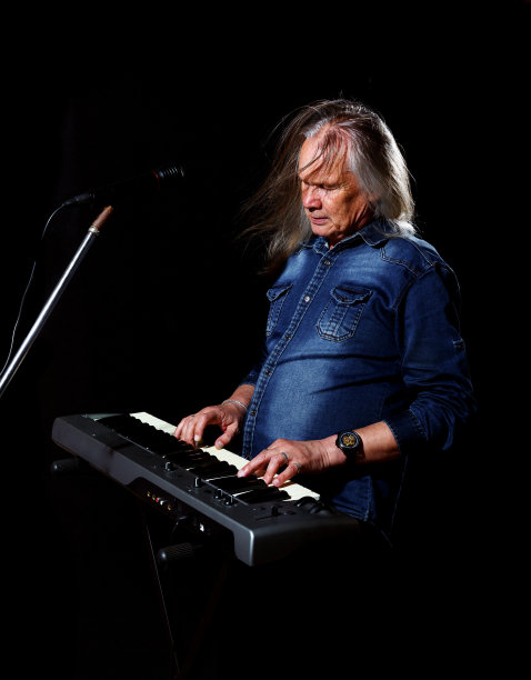 一位白发苍苍的老人在弹奏琴键图片下载