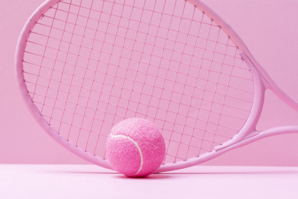粉红色的网球拍和粉红色的球在粉红色的背景。水平运动主题海报，贺卡，标题，网站和应用程序图片下载