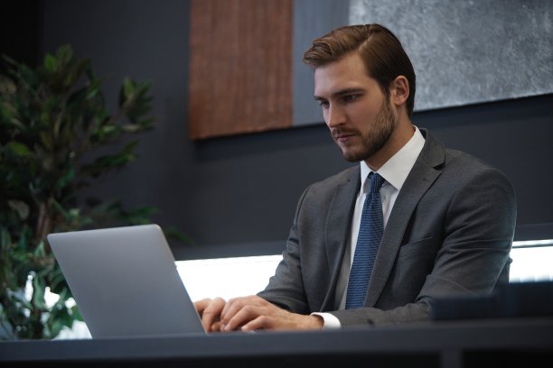 年轻男子沉思的肖像坐在他的办公桌在办公室。图片下载