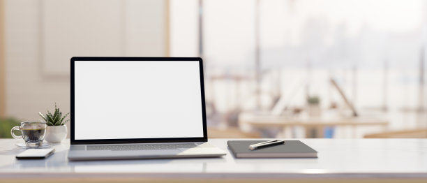 一个笔记本电脑模型和装饰在办公桌上模糊的办公室背景。图片下载