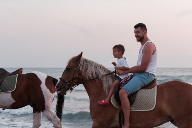 父子俩喜欢一起在海边骑马。有选择性的重点图片下载