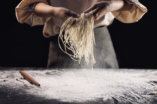 抖出切好的面条，制作中国传统美食手擀面条的过程——高汤照片图片下载