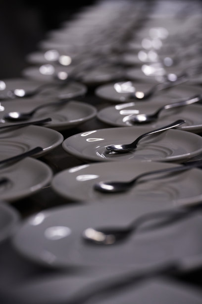 沿吧台或桌子摆放的一长排勺盘图片下载