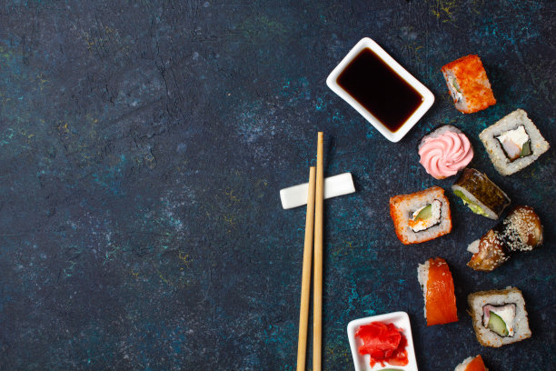 蓝色背景的寿司卷配筷子和酱油。复制空间，俯视图图片下载