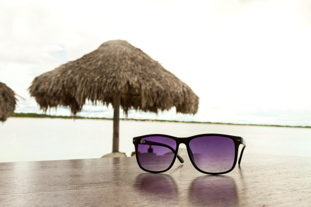 海滩小摊桌上的太阳镜，背景是大海。图片下载