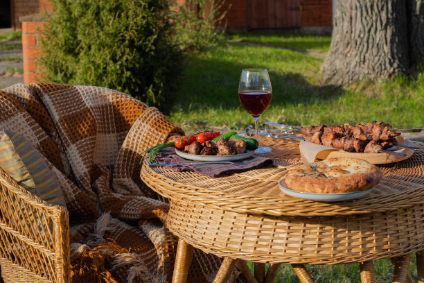 户外野餐，烧烤，蔬菜，美味的面包和一杯酒。图片下载
