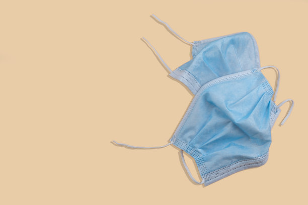 典型的三层外科口罩，用于覆盖口鼻。带橡胶耳带的外科口罩。图片下载