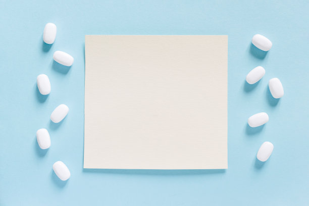 白色药片散落在蓝色的桌子上。模拟特别优惠广告，网页背景或其他想法。医疗、药学和保健理念。副本的空间。空白的地方，文字或标志。图片下载