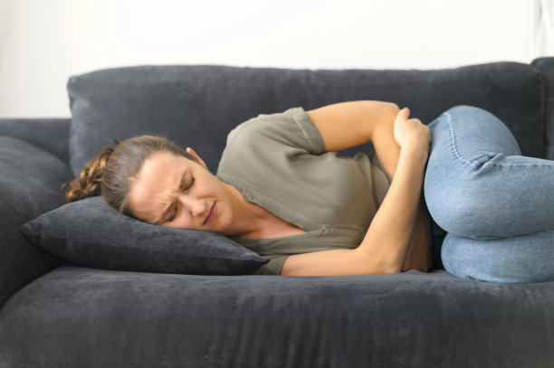 不幸的年轻女子遭受胃痛的折磨图片下载