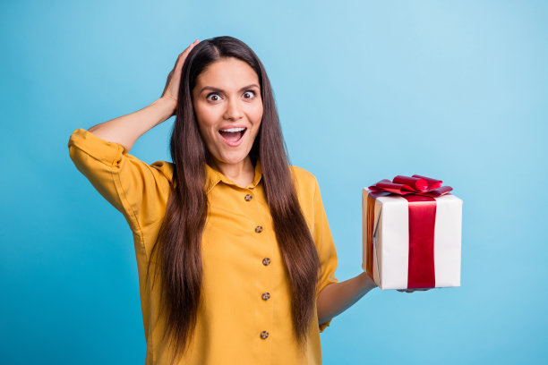 照片肖像惊讶震惊的女人收到了生日派对上的礼物，鲜明的蓝色背景孤立图片下载