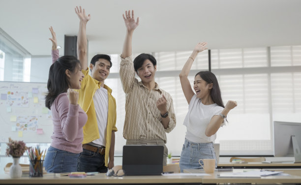 欣喜若狂的年轻人在办公室会议上一起庆祝创业项目的成功。图片下载