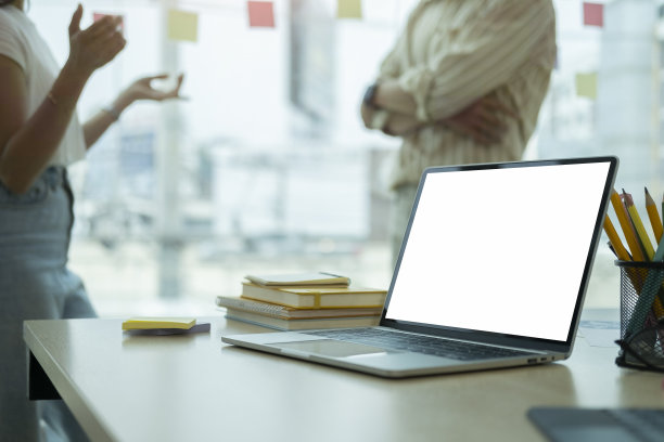 电脑笔记本电脑与空白屏幕和办公用品的木桌在创意合作的工作空间。图片下载