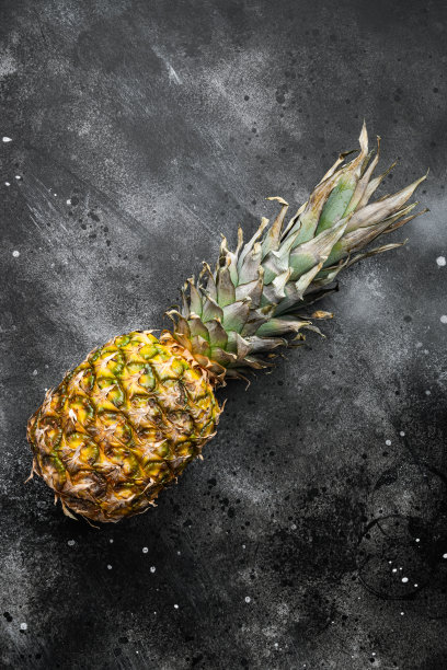 美味的整个菠萝，在黑色深色的石头桌子背景，俯视图平铺，文本的拷贝空间图片下载
