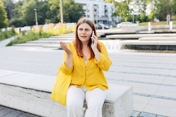 心烦的年轻女人在电话里失望地听到坏消息，悲伤沉思的女孩说有不愉快的智能手机对话和坐在城市街道的长凳上。负面情绪图片下载