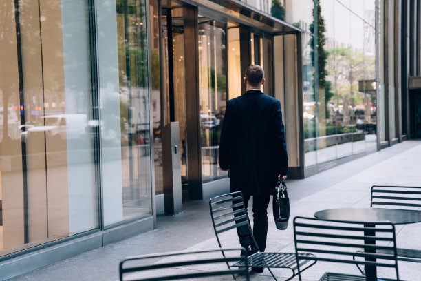穿着黑色外套的商人走在街上图片下载