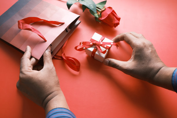 俯视图男人的手拿着一个礼品盒放在桌子上图片下载