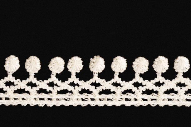黑色背景上的白色花边与复制空间水平隔离。关闭了。缝纫的概念图片下载