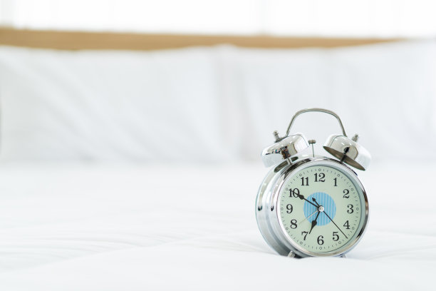 闹钟在床上。图片下载