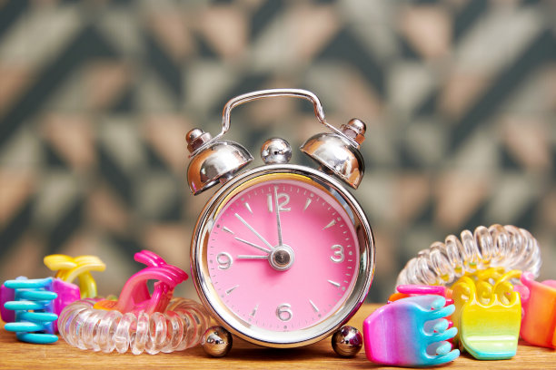 粉红色的花式闹钟，床上有少女发夹图片下载