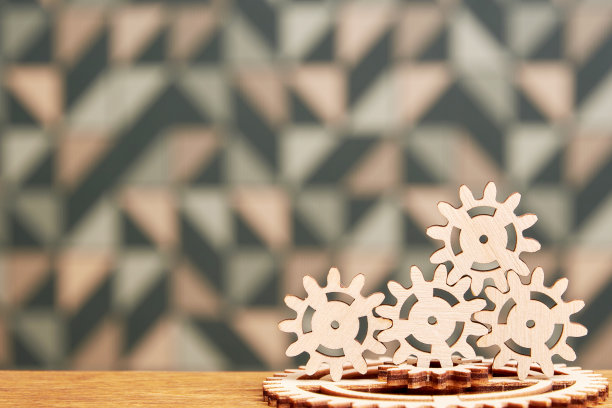 机械装置与一堆木制齿轮连接在桌子上图片下载