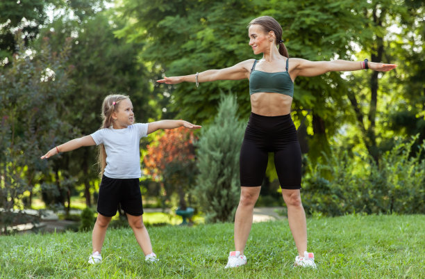 积极的家庭概念。健康的妈妈和小女儿在公园里做户外运动。健康的生活方式。体育课图片下载
