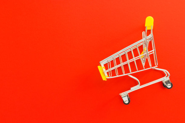 红色背景的迷你超市推车。网上购物的概念。平铺，俯视图，拷贝空间。图片下载