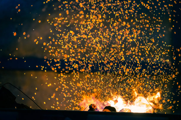火焰和火焰火花与散焦燃烧木炭在黑暗的抽象背景图片下载