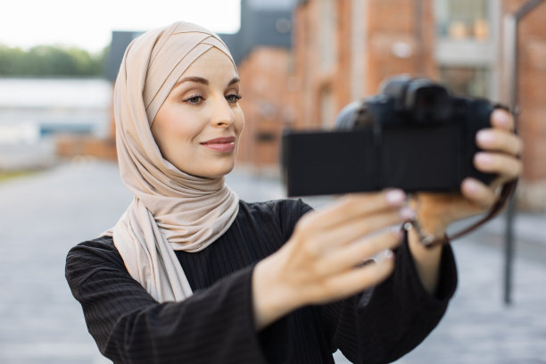 一个阿拉伯女孩用相机自拍。生活方式有问题,背光。图片下载