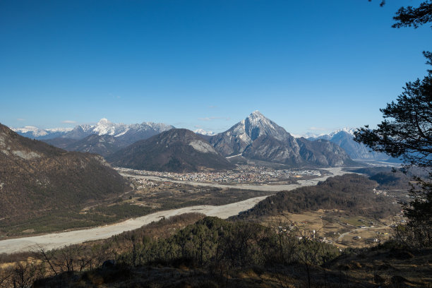 冬季结束时，白天晴朗的淡蓝色天空下，托尔梅佐市被美丽的高山和丘陵环绕，全景尽收眼底图片下载