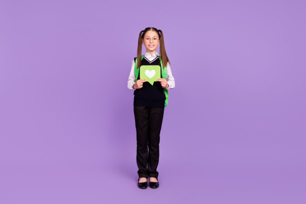 照片中可爱的小女生抱着像卡片一样喜气洋洋的微笑，戴着眼镜，统一孤立的紫罗兰色背景图片下载