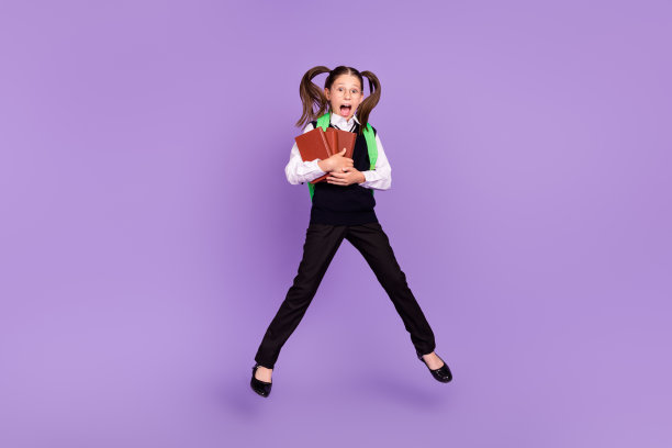 印象深刻的高兴女生的照片跳拿书戴双肩包眼镜统一孤立的紫色背景图片下载