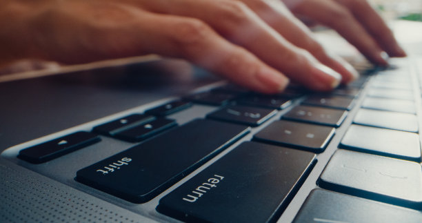 近距离的手年轻的亚洲妇女打字笔记本电脑，而在办公室工作。图片下载