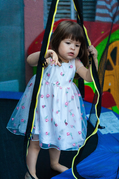 小女孩正在蹦床上玩。图片下载