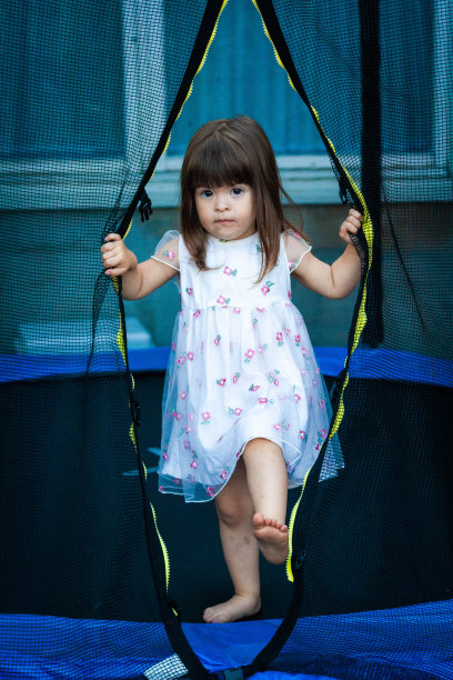 女孩在蹦床上玩完了。图片下载