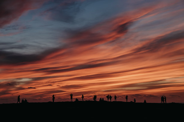有几个人在看日落时泛红的天空图片下载