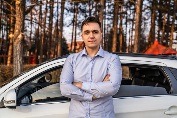 一名男子年轻的成年商人站在他的车在白天户外真人复制空间男性成年人在衬衫与双臂交叉自信地看着相机严肃图片下载