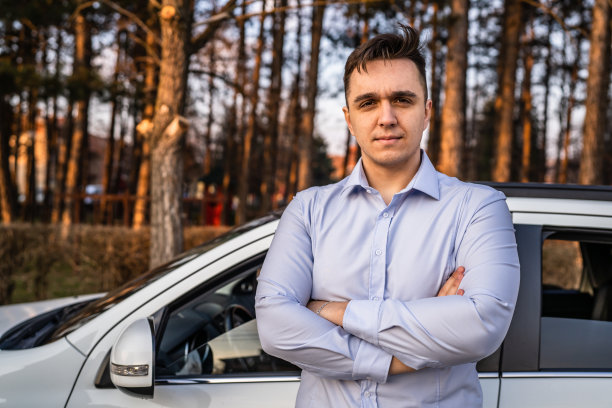 一名男子年轻的成年商人站在他的车在白天户外真人复制空间男性成年人在衬衫与双臂交叉自信地看着相机严肃图片下载