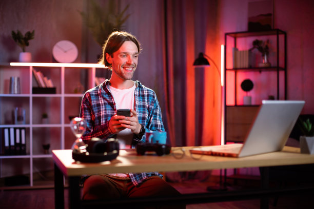 穿着格子衬衫，使用智能手机和笔记本电脑的白人男子图片下载
