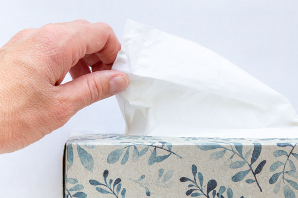 一只手从盒子里拿纸巾的特写。图片下载