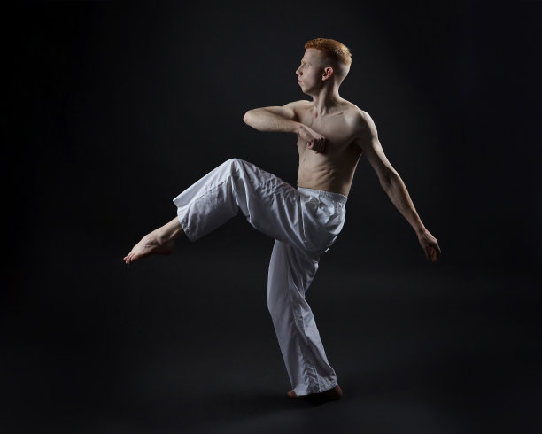 红发男舞者展示舞蹈的舞蹈元素。照片拍摄在工作室的黑色背景图片下载