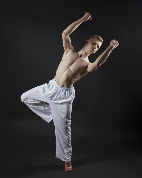 红发男舞者展示舞蹈的舞蹈元素。照片拍摄在工作室的黑色背景图片下载