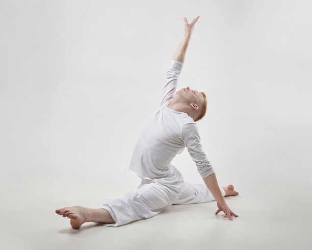红发男舞者展示舞蹈的舞蹈元素。在摄影棚拍摄白底照片图片下载