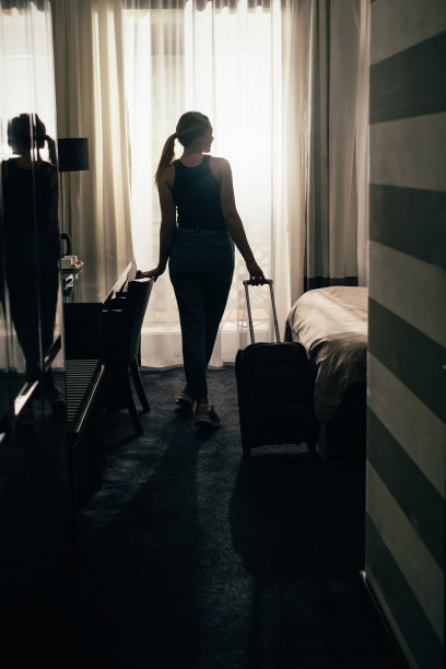 游客带着行李箱入住豪华客房，欣赏窗外美景图片下载