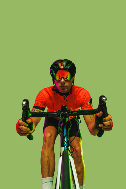 运动员的前摄像头视图，骑自行车的人在红色运动服和防护头盔隔离在绿色背景。图片下载