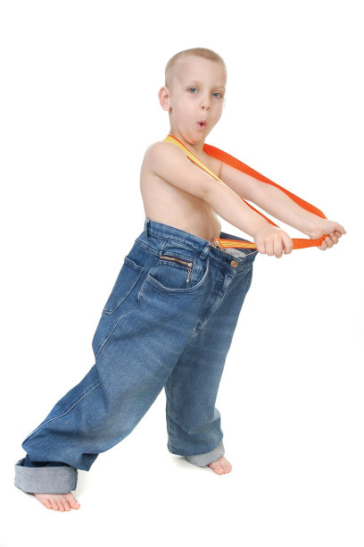 一个男孩穿着大码牛仔裤和背带的照片图片下载