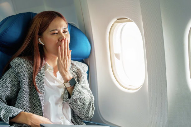 一个成功的亚洲女商人或企业家的肖像，穿着正装在商务舱的飞机上，从航班间隙的休息中醒来图片下载