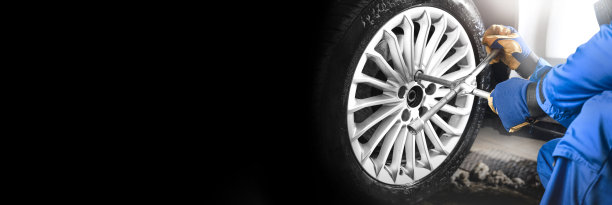 机械师更换轮胎，黑色的复印空间用于文字修复服务中心，模糊的背景，图片下载