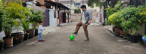 亚洲父子在户外踢足球图片下载